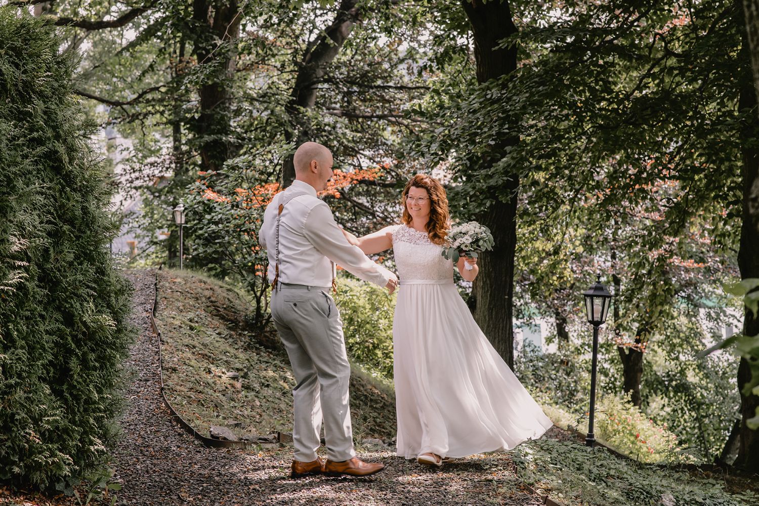Detailaufnahme von Brautkleid und Fliederstrauß
